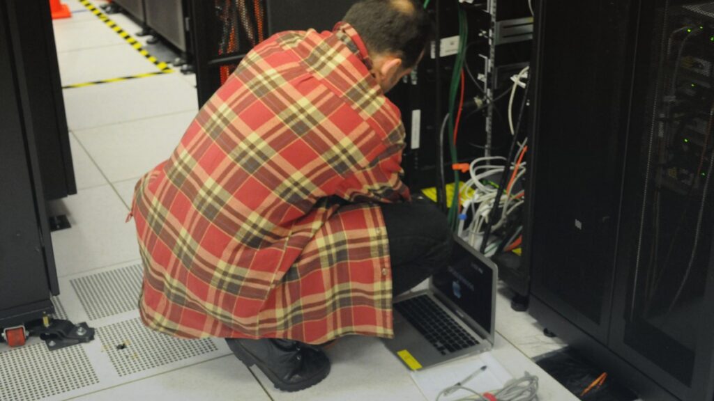 Technicien travaillant sur des serveurs, illustration de l’infrastructure IA