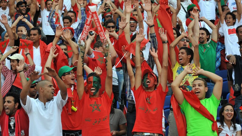 Supporters marocains célébrant dans les tribunes lors d’un match de football