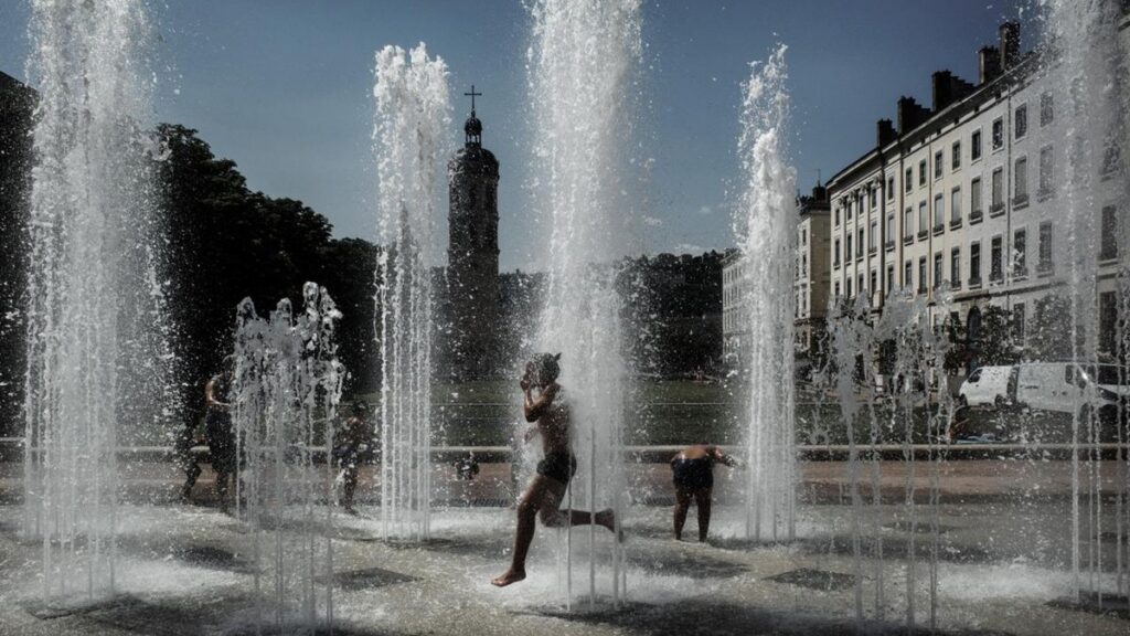 Des personnes se rafraîchissent dans des fontaines pendant une vague de chaleur en France