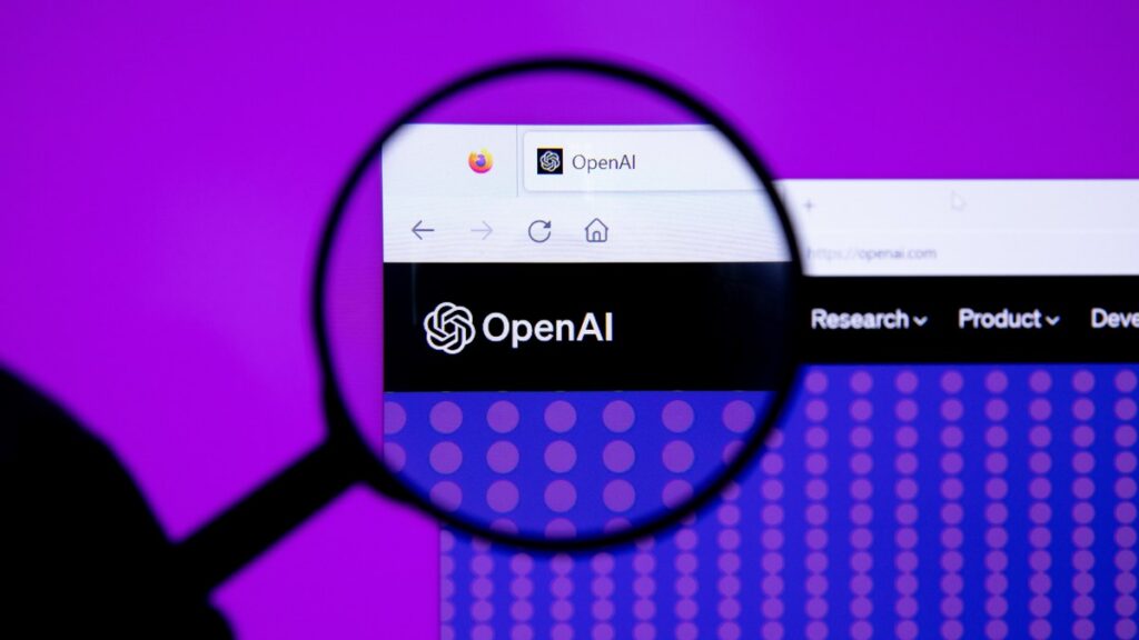 Logo d’OpenAI affiché sur un écran derrière une loupe