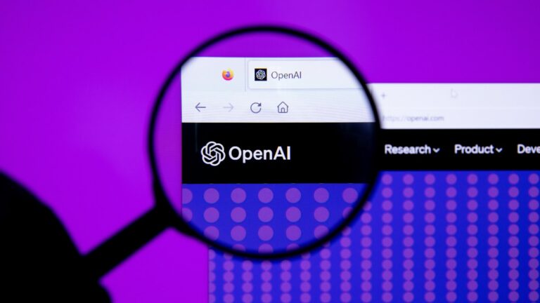 Logo OpenAI affiché sur un écran, vu à travers une loupe